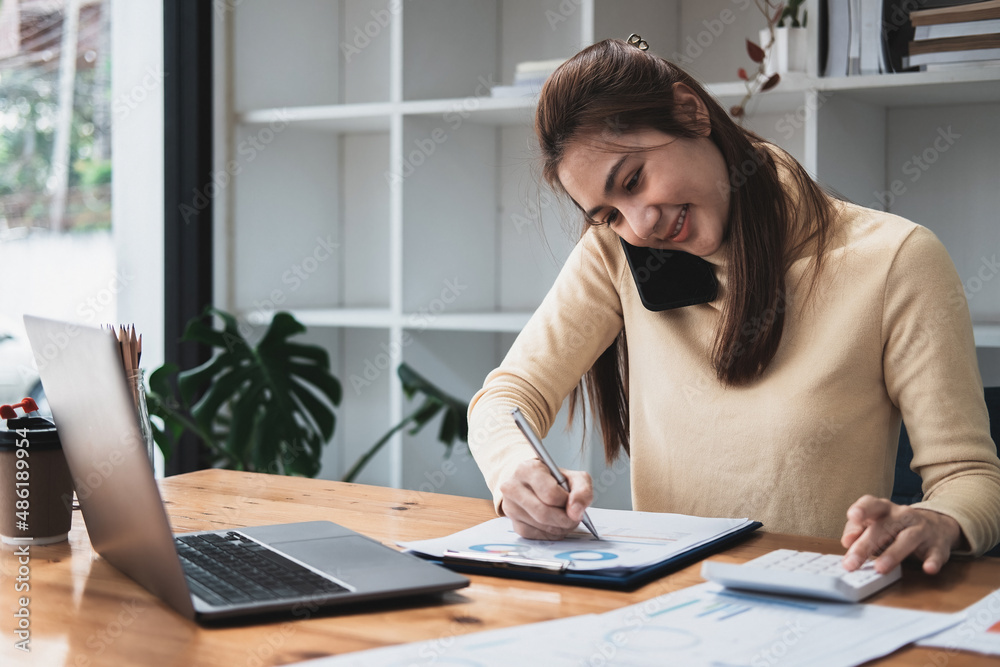 Asian business woman making a phone call, Accountant working Financial investment on calculator with calculate Analyze business and market growth on financial document data graph and writing.