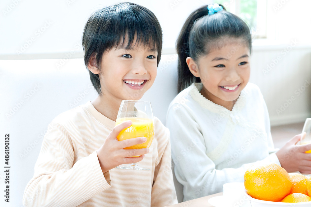 オレンジジュースを飲む男の子と女の子 オレンジジュースを飲む男の子と女の子