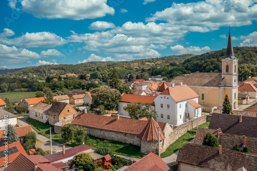 Aerial view of Szaszvar medieval castle and fortified manor house, with red roof, small circle tower and walls in Baranya country Hungary