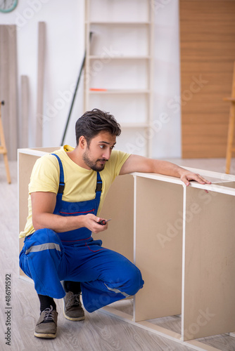 Young male carpenter working at home