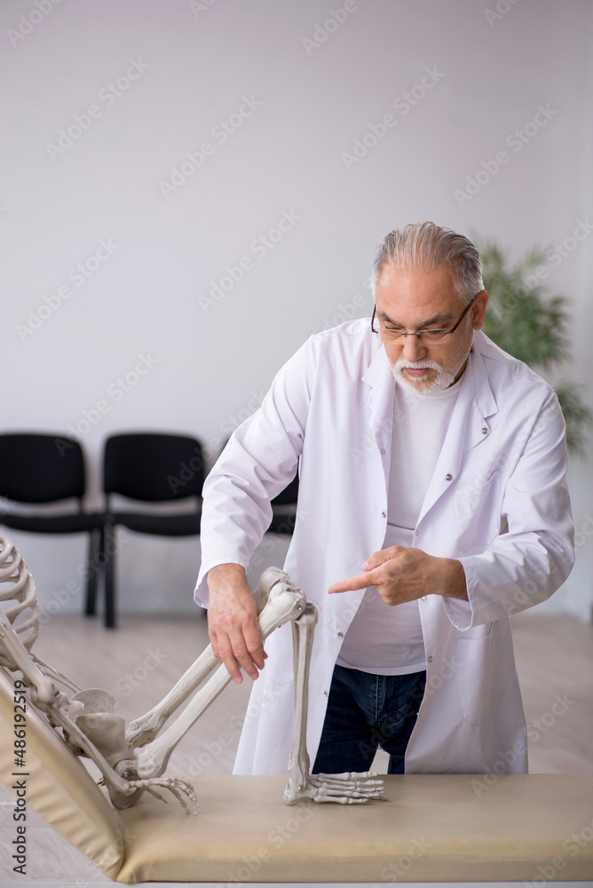 © Elnur - Old male doctor with skeleton in the clinic