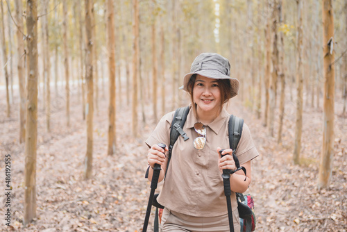 Asian woman hiking trail and trekking in the forest alone. Travel and outdoor activity. Relax and recreation in autumn holiday. photo