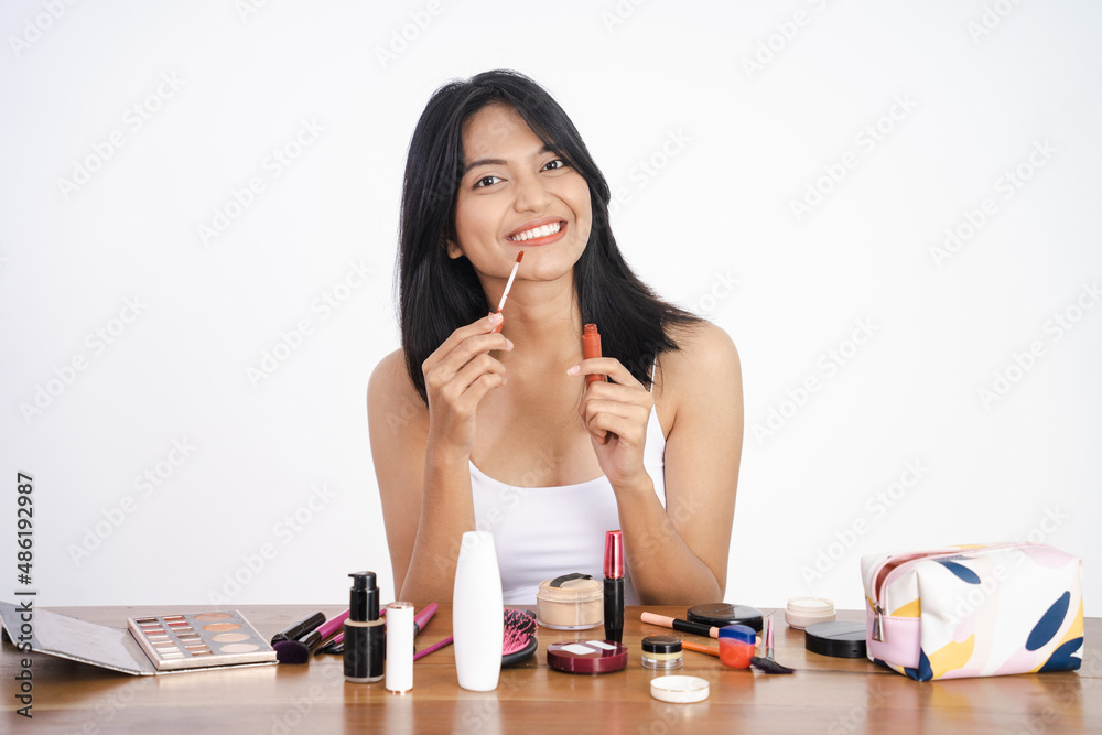 woman applying lipstick on her lip on white background woman applying lipstick on her lip on white background