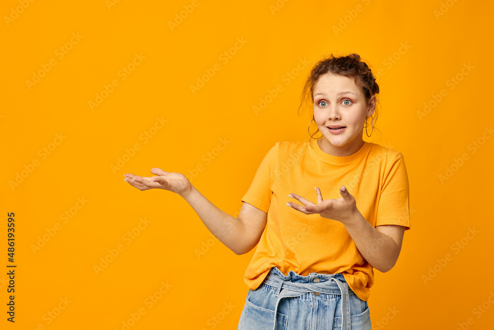 cheerful woman in a yellow t-shirt posing emotions yellow background unaltered cheerful woman in a yellow t-shirt posing emotions yellow background unaltered