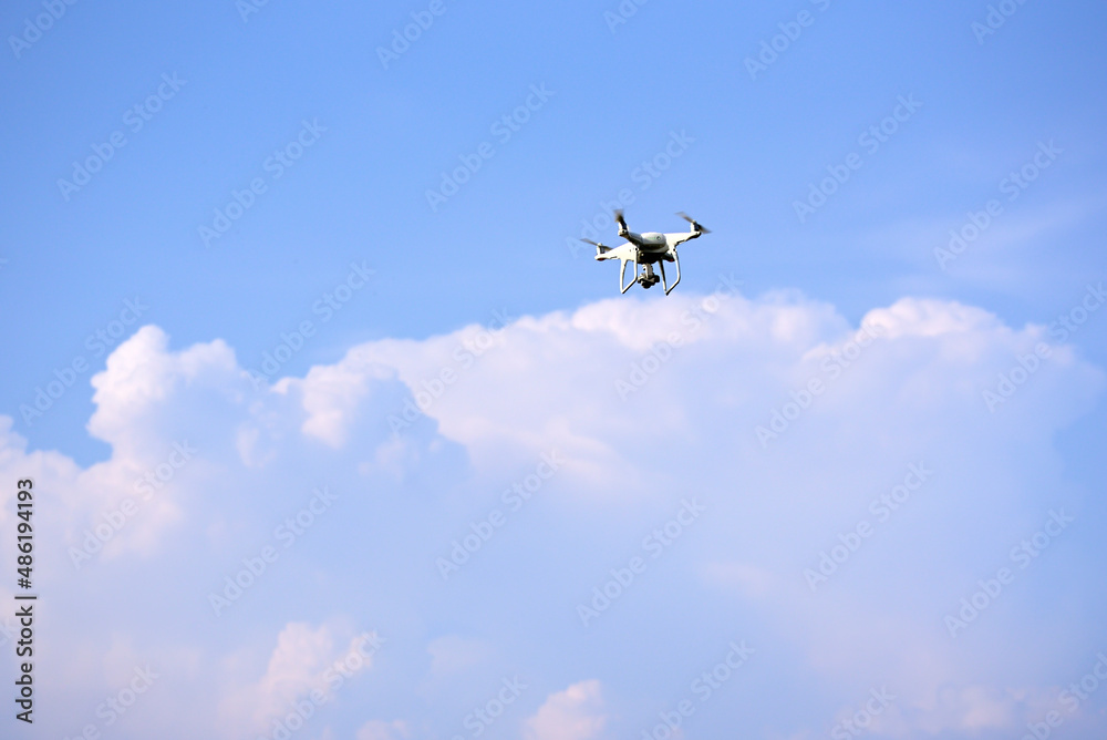 Close-up of drone is flying against isolated blue sky Close-up of drone is flying against isolated blue sky