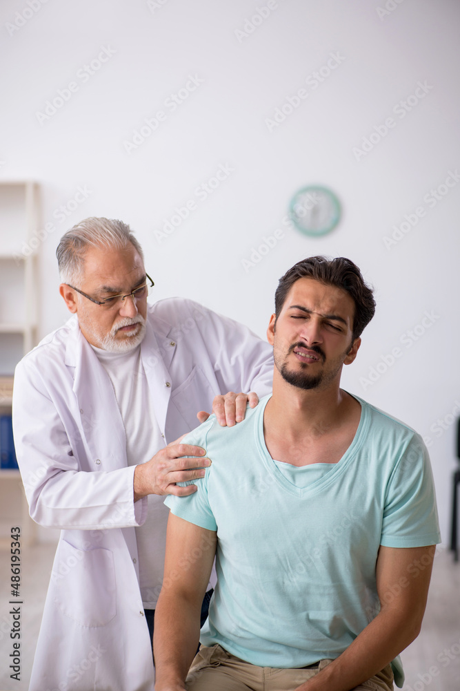 Obraz premium Young male patient visiting old male doctor