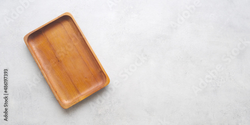 Empty wooden plate on gray cement table background, banner with copy space, Blank wood tray for food display montage, template, mock up, top view, flat lay