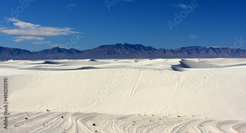 the vast expanses of  gypsum sand dunes against  the san andres mountains in white sands national park near alamogordo, new mexico photo