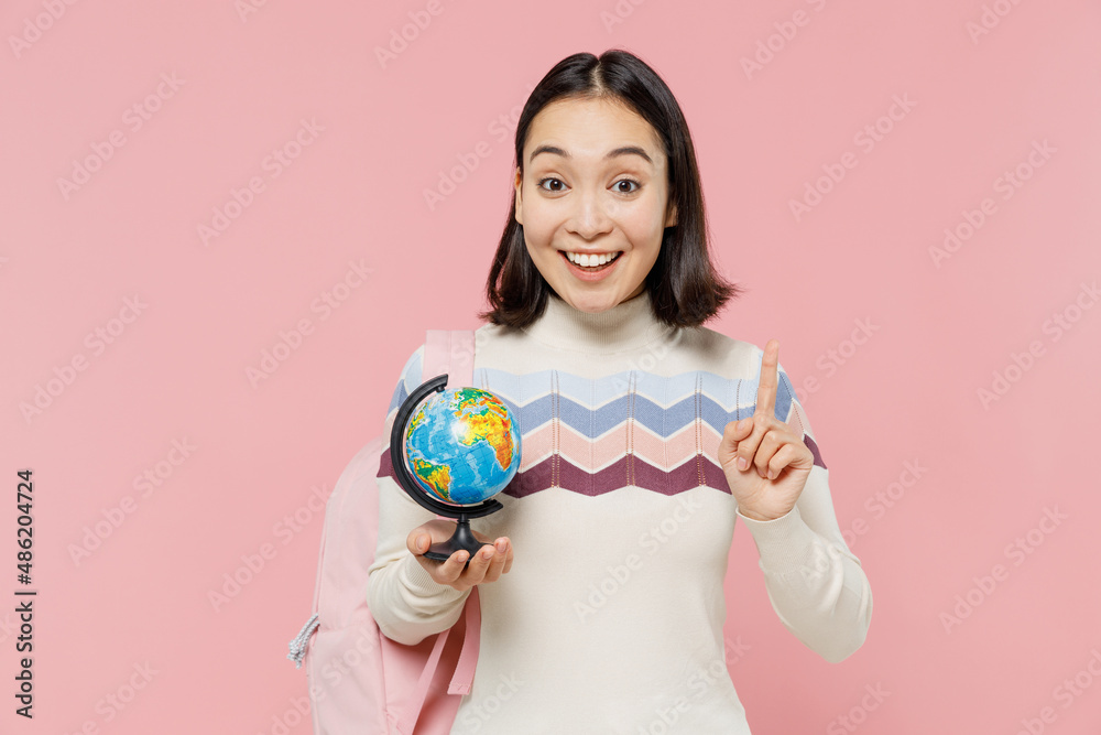 Teen student girl of Asian ethnicity in sweater backpack hold books hold in hands Earth world globe point finger up isolated on pastel plain pink background Education in university college concept Teen student girl of Asian ethnicity in sweater backpack hold books hold in hands Earth world globe point finger up isolated on pastel plain pink background Education in university college concept