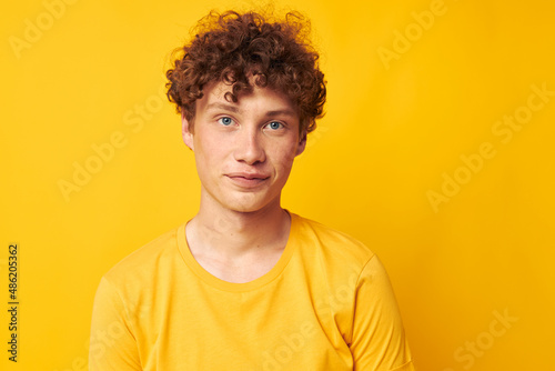 cute red-haired guy yellow t-shirt fashion hand gestures yellow background unaltered