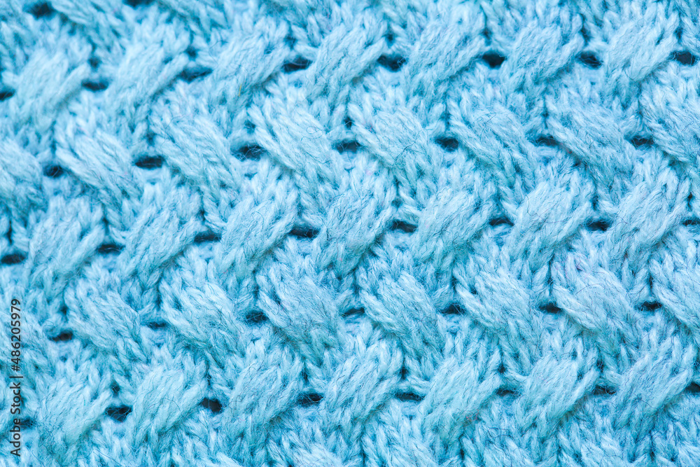 Knitted surface of woolen things as a background. Close-up of soft blue knitted patterns texture. Warm winter clothes. Background textile surface with copy space for text. Knitted surface of woolen things as a background. Close-up of soft blue knitted patterns texture. Warm winter clothes. Background textile surface with copy space for text.