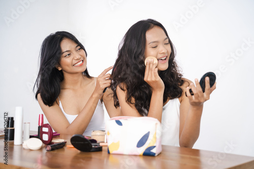 two asian beautiful happy friend while doing make up