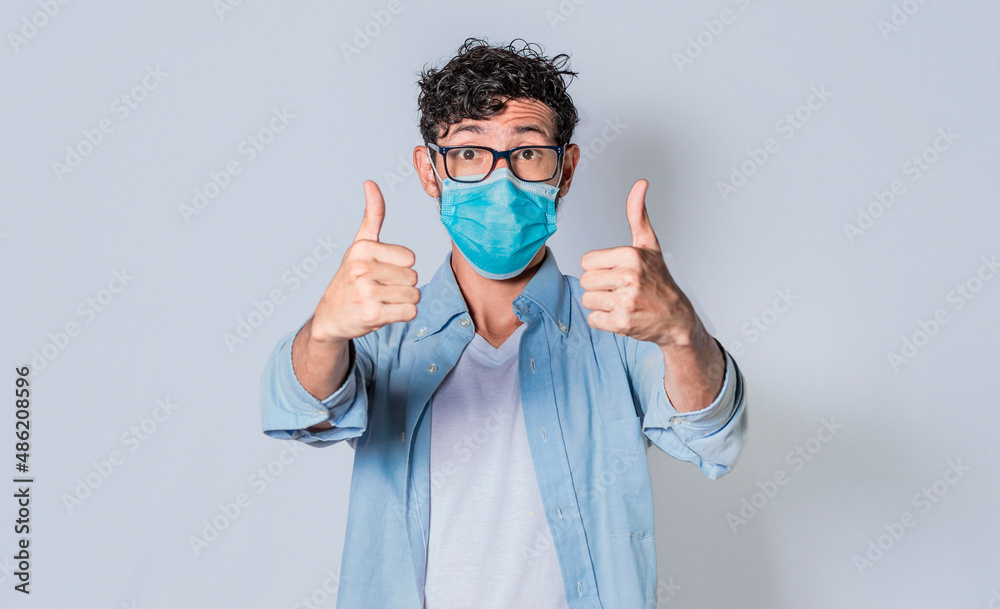 Man with mask on and thumbs up, Latino guy giving thumbs up with mask on. Man with mask on and thumbs up, Latino guy giving thumbs up with mask on.