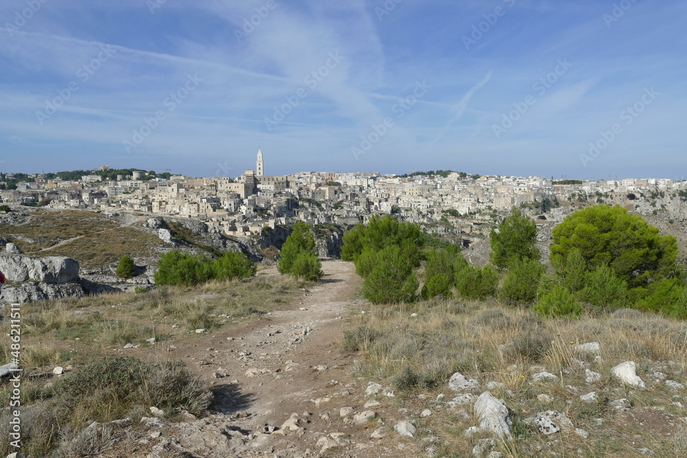 path in Murgia Materana Park with the canyon and Matera old town in the background