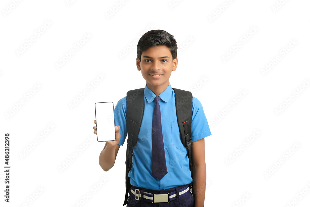 technology concept: Cute indian little school boy showing smartphone technology concept: Cute indian little school boy showing smartphone