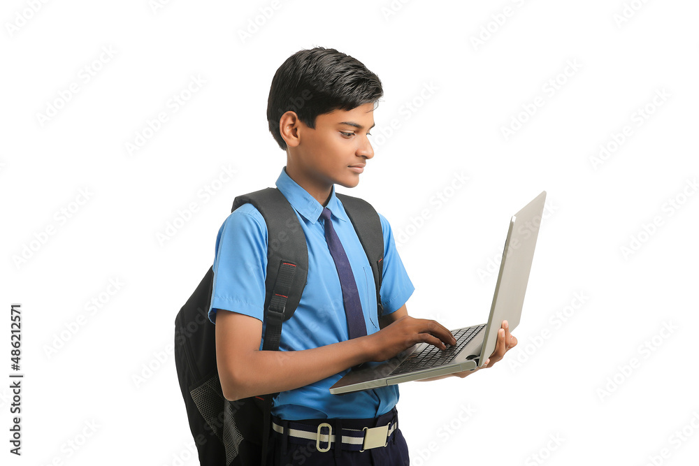 Indian school boy in uniform and using laptop on white background. Indian school boy in uniform and using laptop on white background.