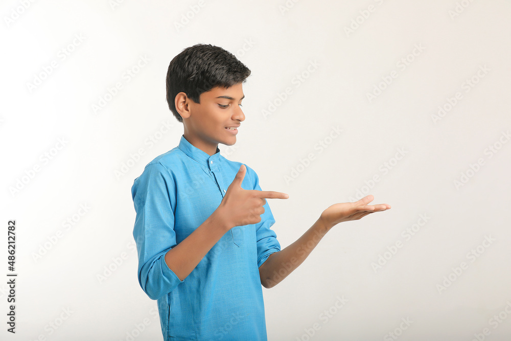 Indian boy in traditional wear and giving hand expression on white background. Indian boy in traditional wear and giving hand expression on white background.