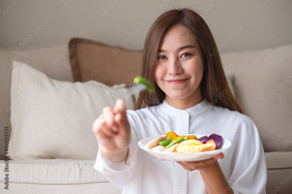 Portrait image of a young woman eating vegetables, Vegan, Clean food, dieting concept