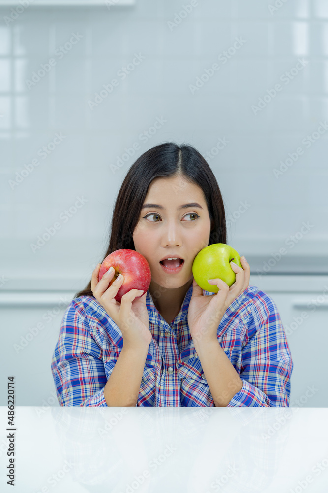 asian woman happy holding green apple and red apple. asian woman happy holding green apple and red apple.