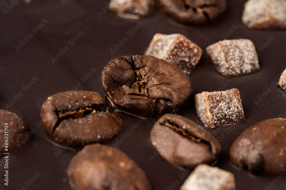 Close up of dark chocolate bar with coffee beans and candied fruit Close up of dark chocolate bar with coffee beans and candied fruit