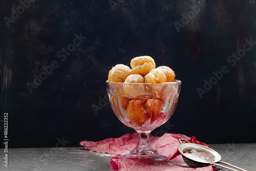 Italian carnival fritters dusted with powdered sugar in pink glass bowl. With free text space. photo