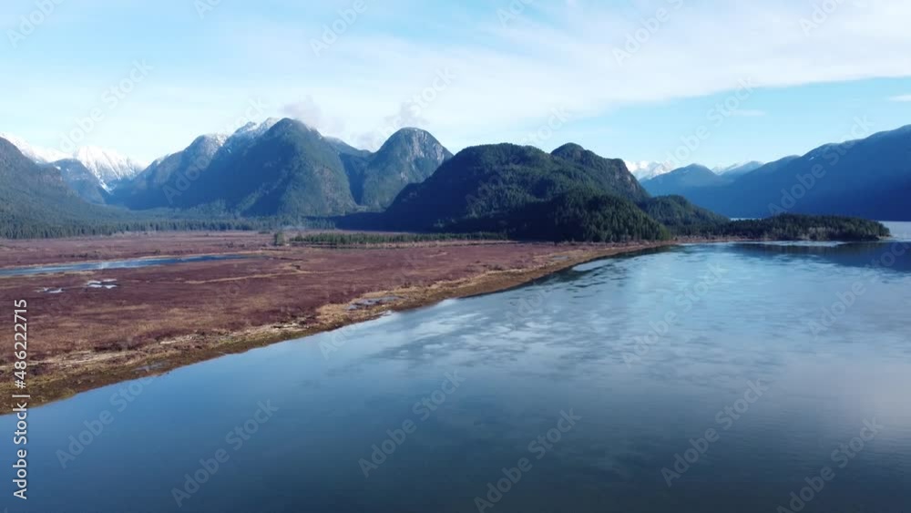 Winter Sunrise in a natural meadows along river from a glacier lake, surrounded by mountains, marsh and icy water. Winter Sunrise in a natural meadows along river from a glacier lake, surrounded by mountains, marsh and icy water.