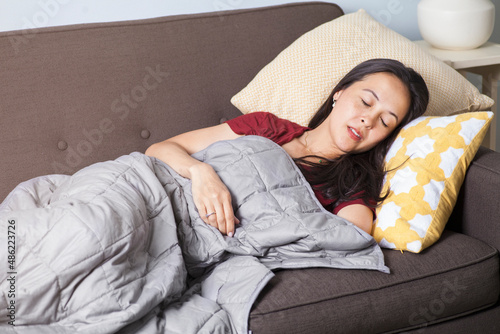 Photography Woman sleeps on couch with weighted blanket