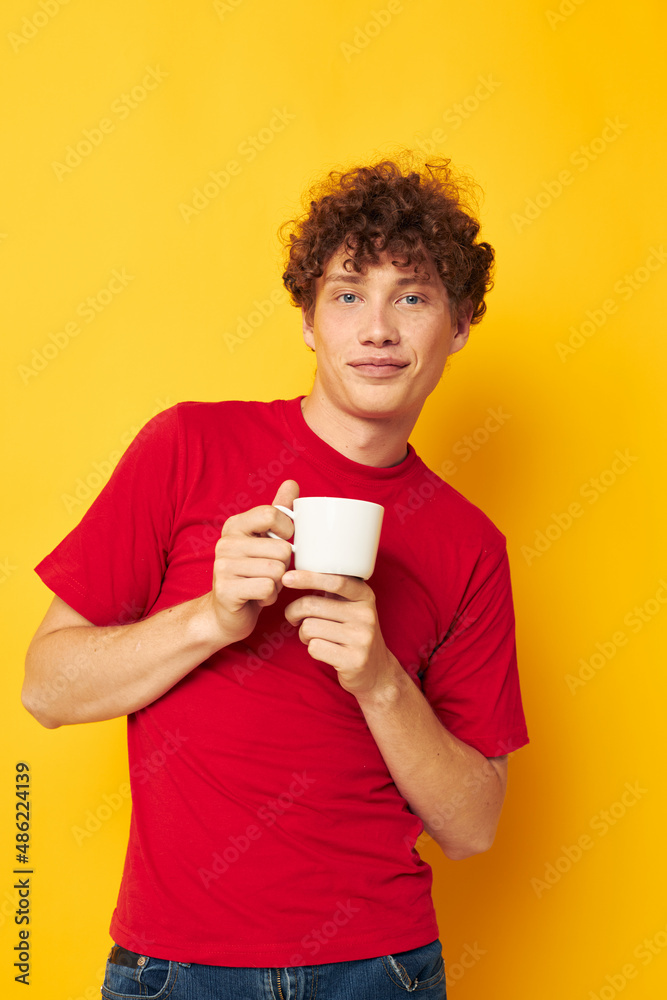 cute red-haired guy posing with a white mug and in the hands of a drink Lifestyle unaltered cute red-haired guy posing with a white mug and in the hands of a drink Lifestyle unaltered