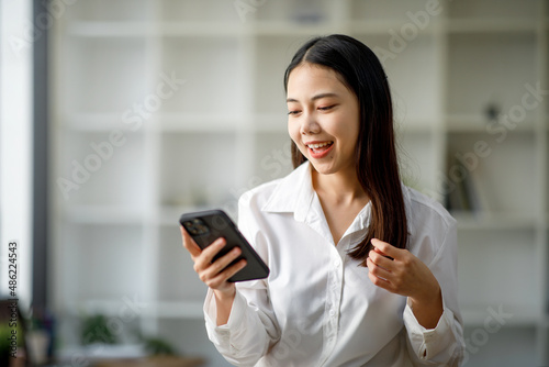 Portrait of a happy Asian businesswoman using mobile phone indoor, Asian businesswoman working in modern office. Free Download Portrait of a happy Asian businesswoman using mobile phone indoor, Asian businesswoman working in modern office. - GFXLoad
