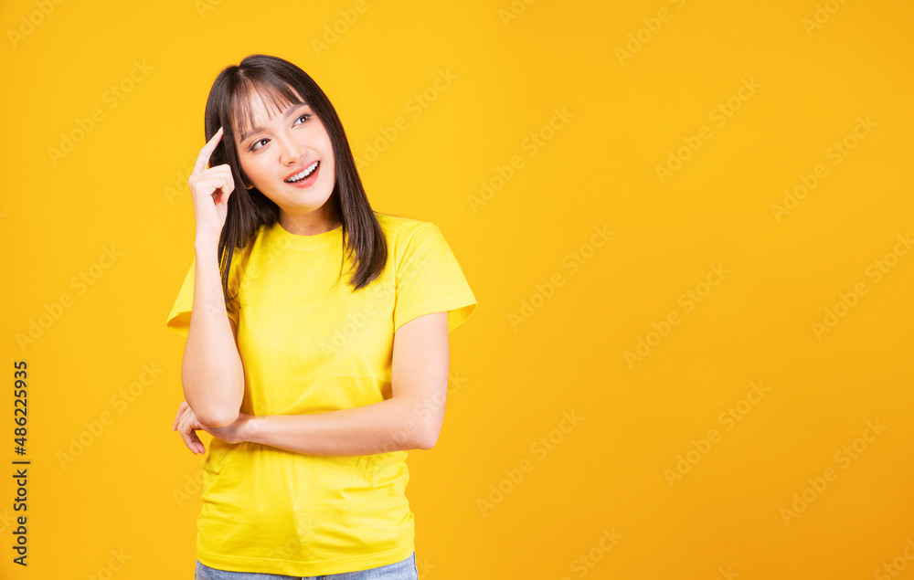 Positive Asian woman think choice creative on yellow background. Smile girl thinking about question, pensive expression something over isolated. Lady thoughtful doubt holding finger on head looking up Positive Asian woman think choice creative on yellow background. Smile girl thinking about question, pensive expression something over isolated. Lady thoughtful doubt holding finger on head looking up