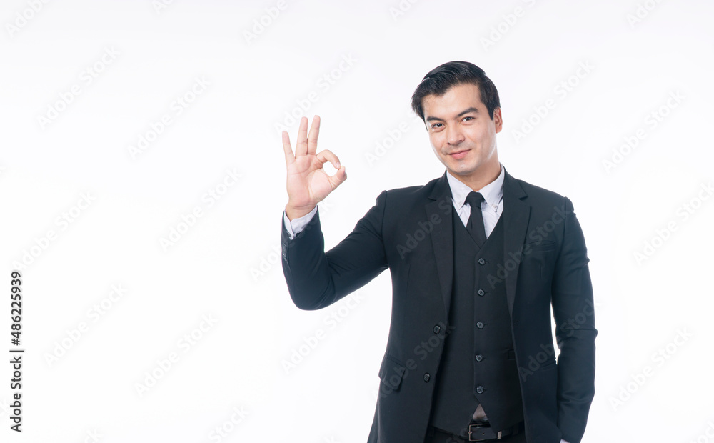 Confident smile handsome businessman wear suit using finger make sign ok for good idea or job while standing over isolated white background. Agreement, winner, business successful concept. Confident smile handsome businessman wear suit using finger make sign ok for good idea or job while standing over isolated white background. Agreement, winner, business successful concept.