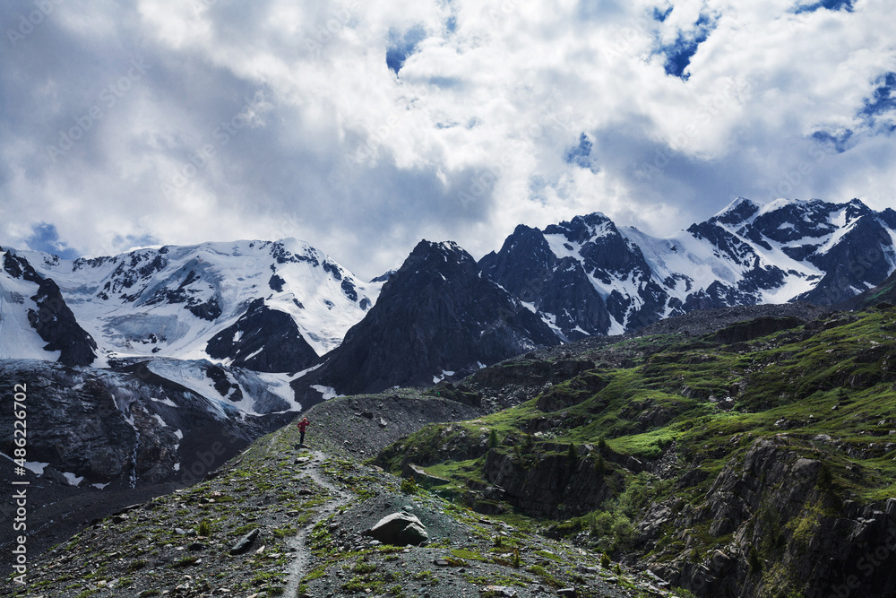 a narrow path along the crest of the ridge in the Altai mountains with a view of the glacier