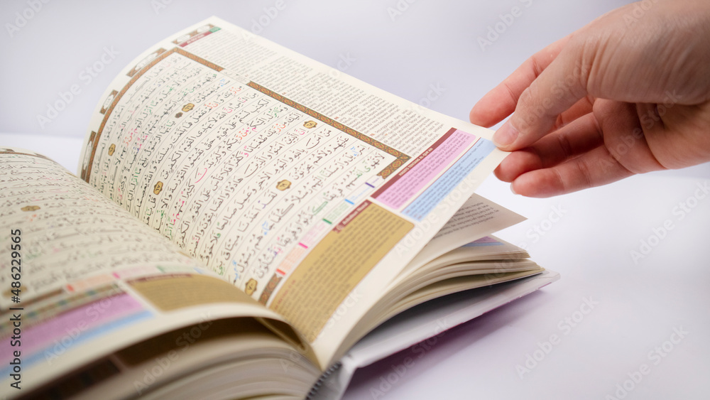 Obraz premium hand fliping one sheet of holy quran