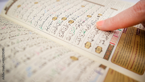 finger point on holy quran extreme close up photo