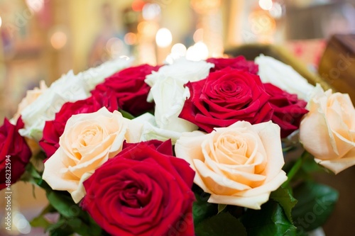 Bouquet of red  white and cream roses  blurry background of burn