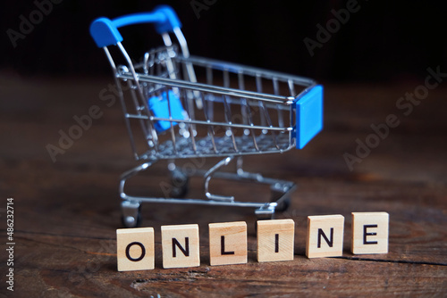 Online inscription and shopping cart on a wooden background. The concept of Internet marketing and online sales.