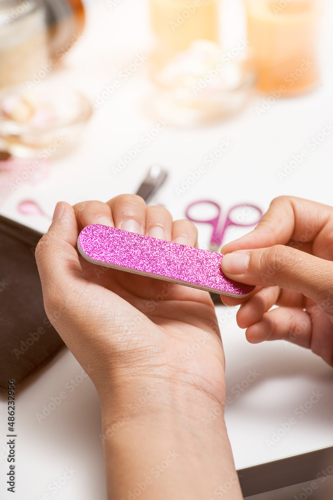 Pink glitter pedicure and manicure set being used on fingernails