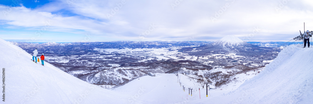 Panoramic view of snowy volcano and town seen from a ski resort (Niseko, Hokkaido, Japan)
