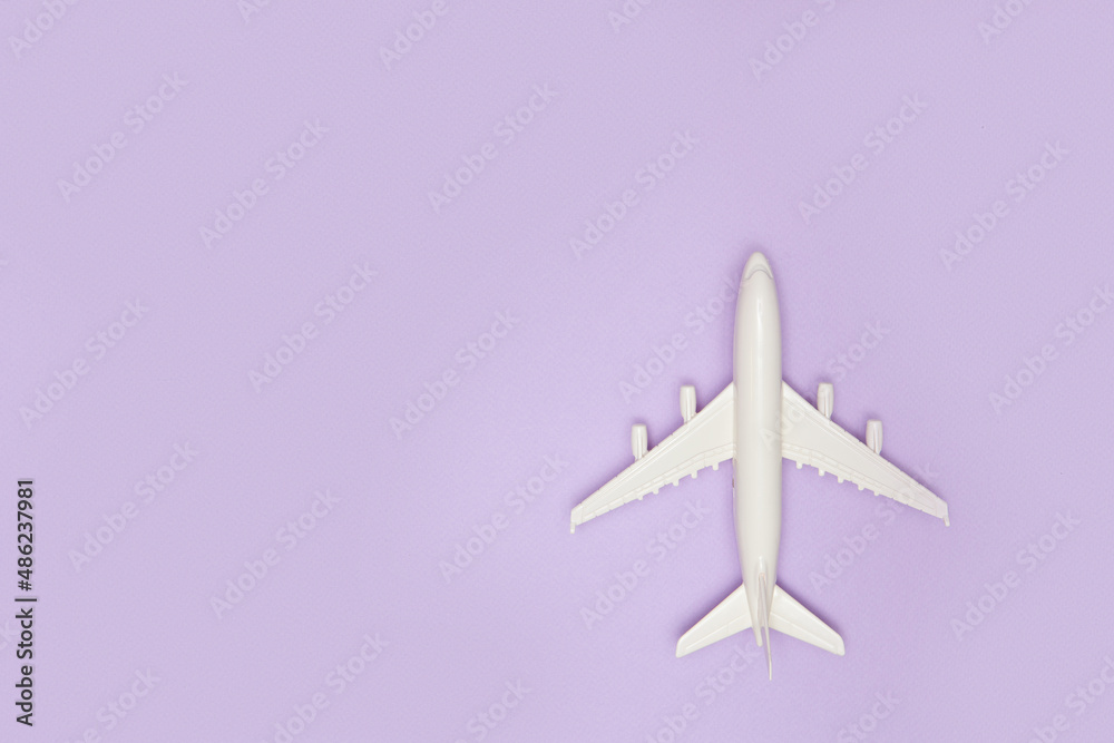 Airplane model. White plane on purple background. Travel vacation concept. Summer background. Flat lay. Airplane model. White plane on purple background. Travel vacation concept. Summer background. Flat lay.