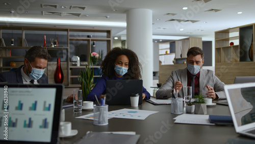 Multiracial business group talk share ideas. Coworkers wear covid safety masks.