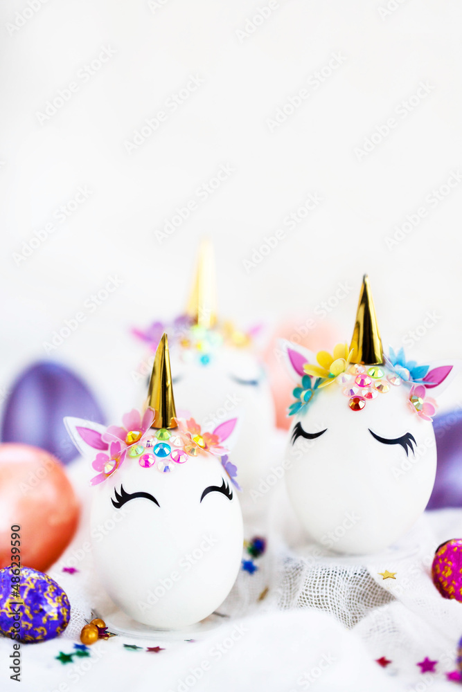 Easter eggs in the form of a unicorn on white background, copy space for text, close-up