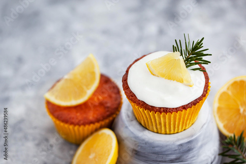 Homemade delicious lemon cupcakes, decorated with creamcheese and fresh citrus fruits photo