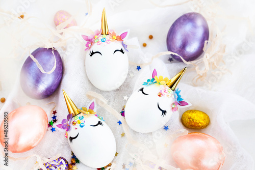 Easter eggs in the form of a unicorn on white background, copy space for text, top view, flat lay