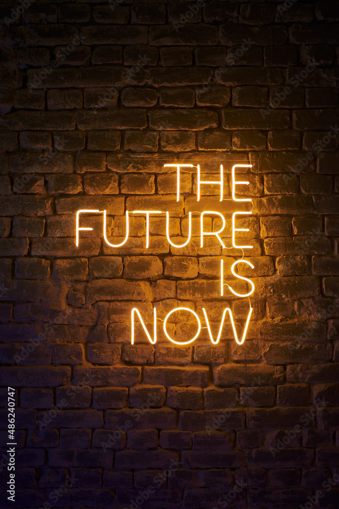 neon glowing inscription on the wall the future is now