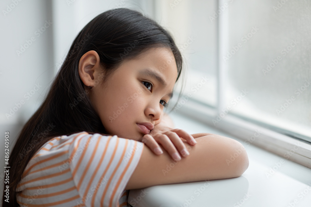 Side view of korean little girl feeling down, closeup Side view of korean little girl feeling down, closeup