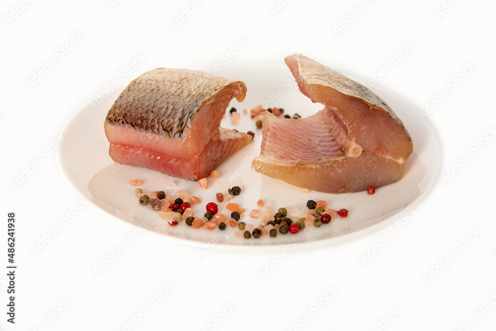 Salted omul fish with spices and salt on a plate. Foods rich in protein. Salted omul fish with spices and salt on a plate. Foods rich in protein.
