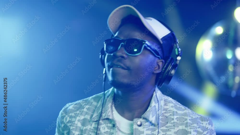 Mid adult African man dancing in beat and expressing emotions. Nightlife, modern music and entertainment concept.