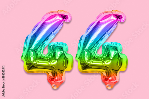 Rainbow foil balloon number, digit forty four on a pink background. Birthday greeting card with inscription 44. Top view. Numerical digit. Celebration event, template. photo