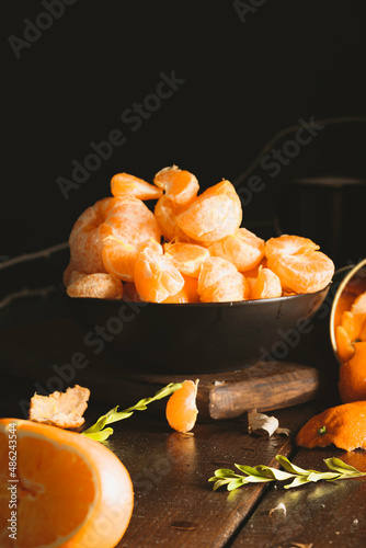 Juicy tangerines falling on dark backgorund