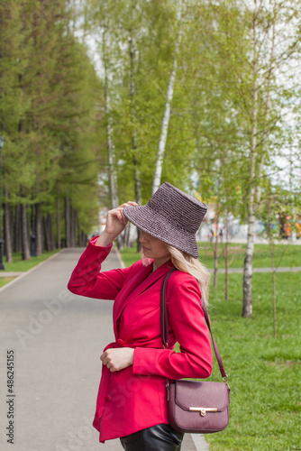 Beautiful blonde in a red jacket and hat. City Style
